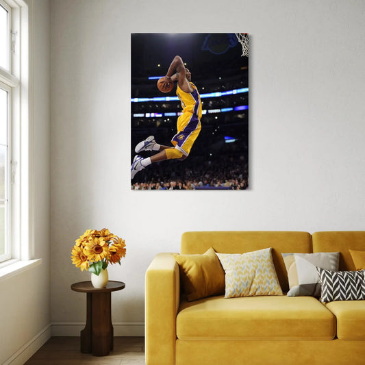 Living room with a yellow couch, small table with flowers, and a large framed picture of a basketball player on the wall.
