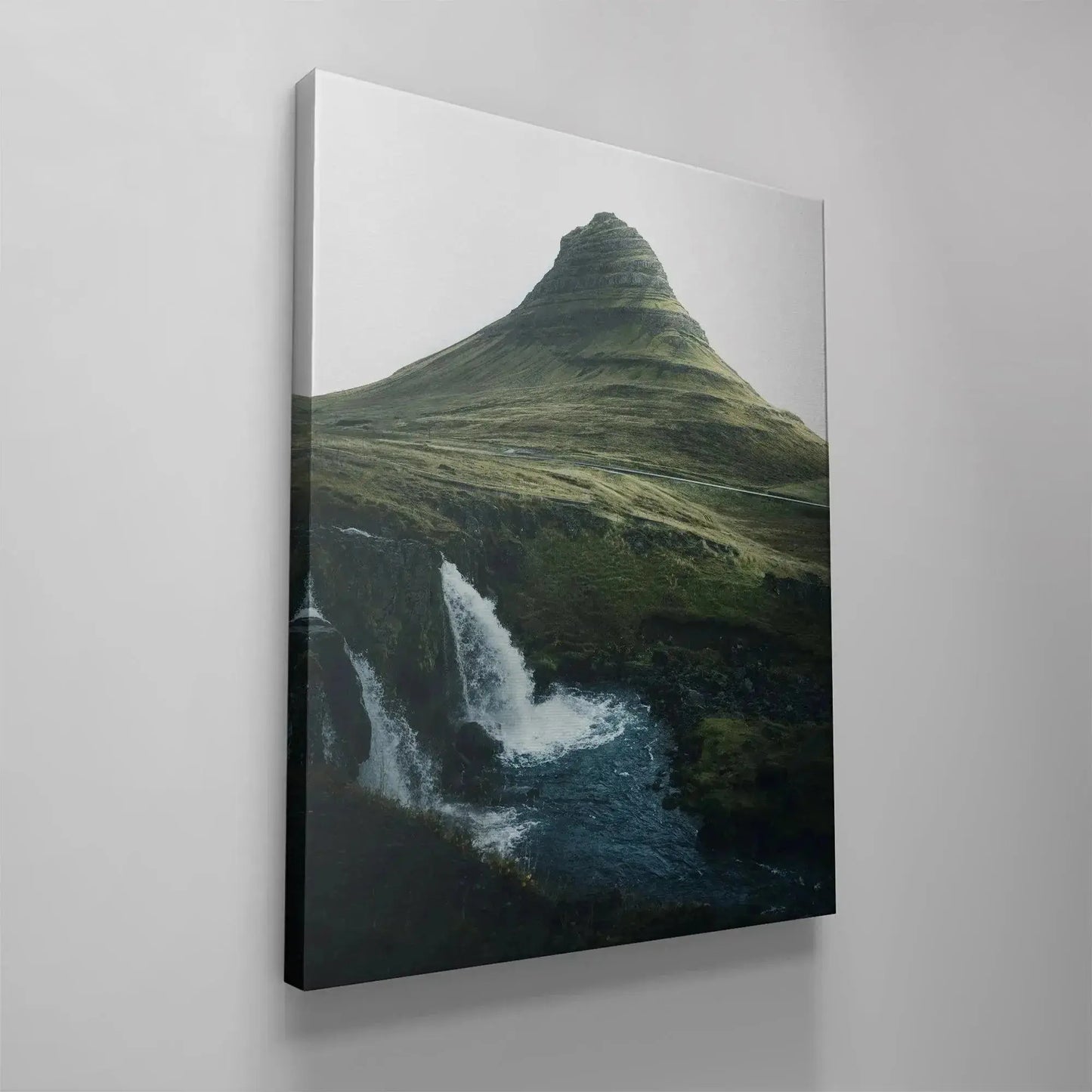 The dark blue river meeting the black volcanic rock formations beneath the cascading falls in '(N)iceland'.