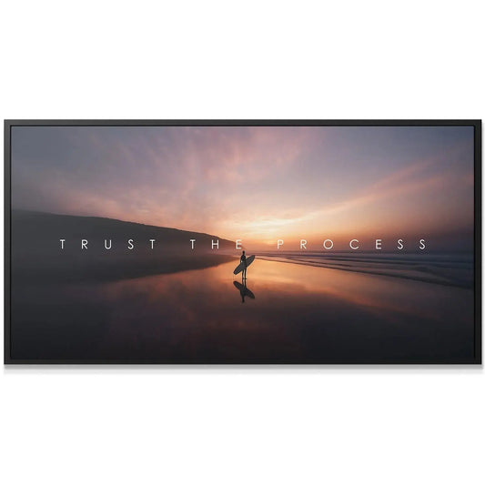 Surfer silhouette holding surfboard on wet beach sand at twilight; 'Action Sports - Trust The Process' overlay.