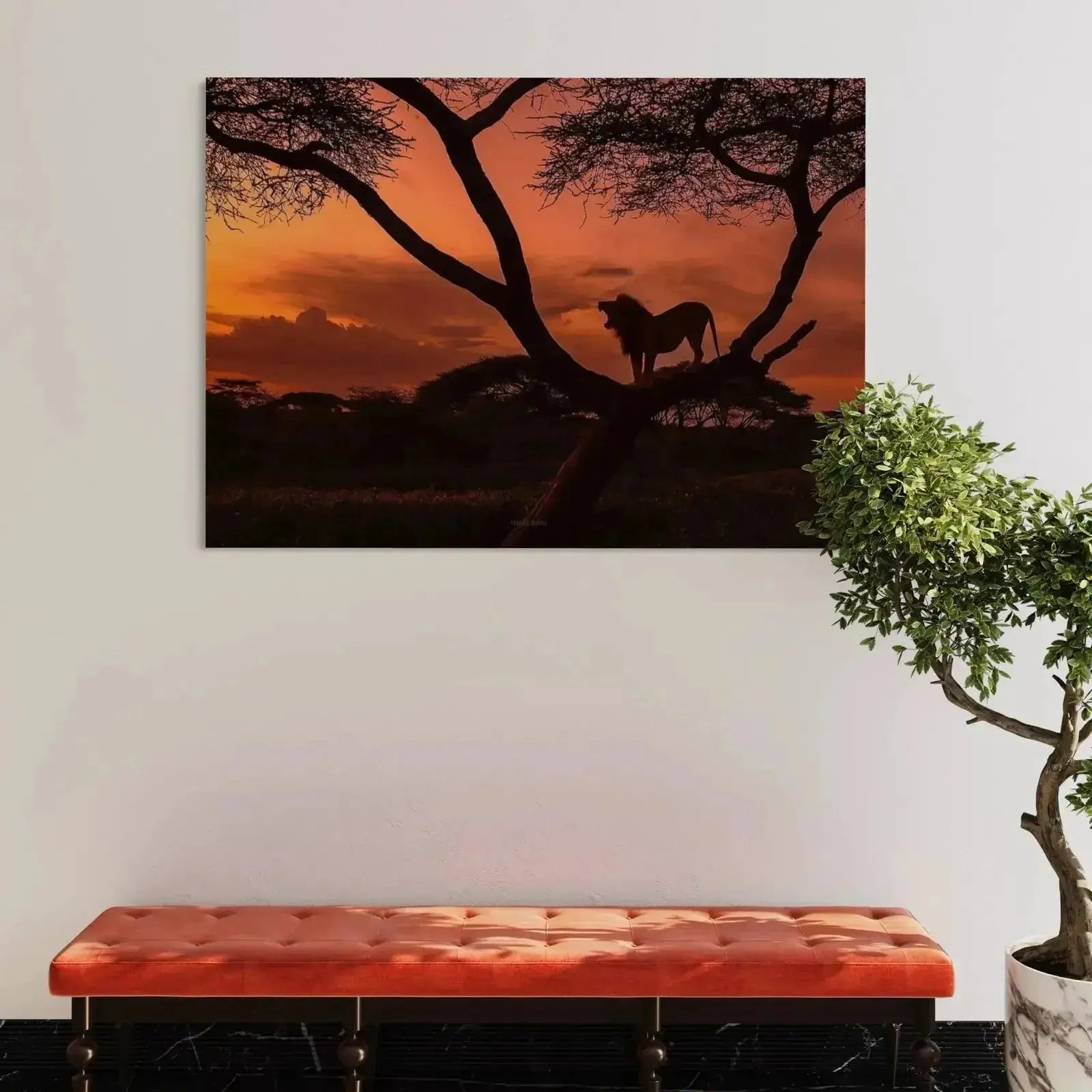 Vibrant orange and red sky contrast behind a powerful male African lion figure.
