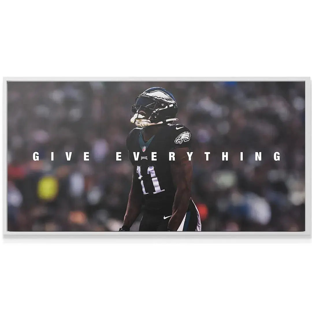 Lifestyle photo of the AJ Brown - Give Everything artwork hanging above a modern minimalist desk setup.