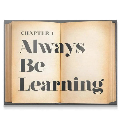 Full view of the open book print displaying the large text 'Always Be Learning' on aged, yellowed paper.