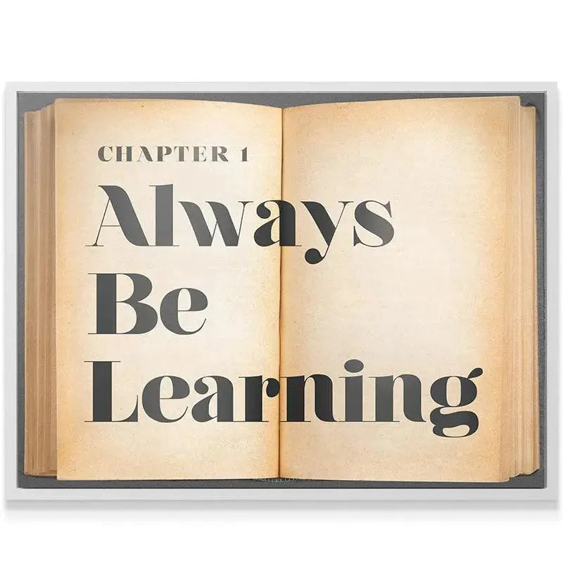 Angled shot of the motivational poster hanging framed in a modern study, emphasizing 'Always Be Learning'.
