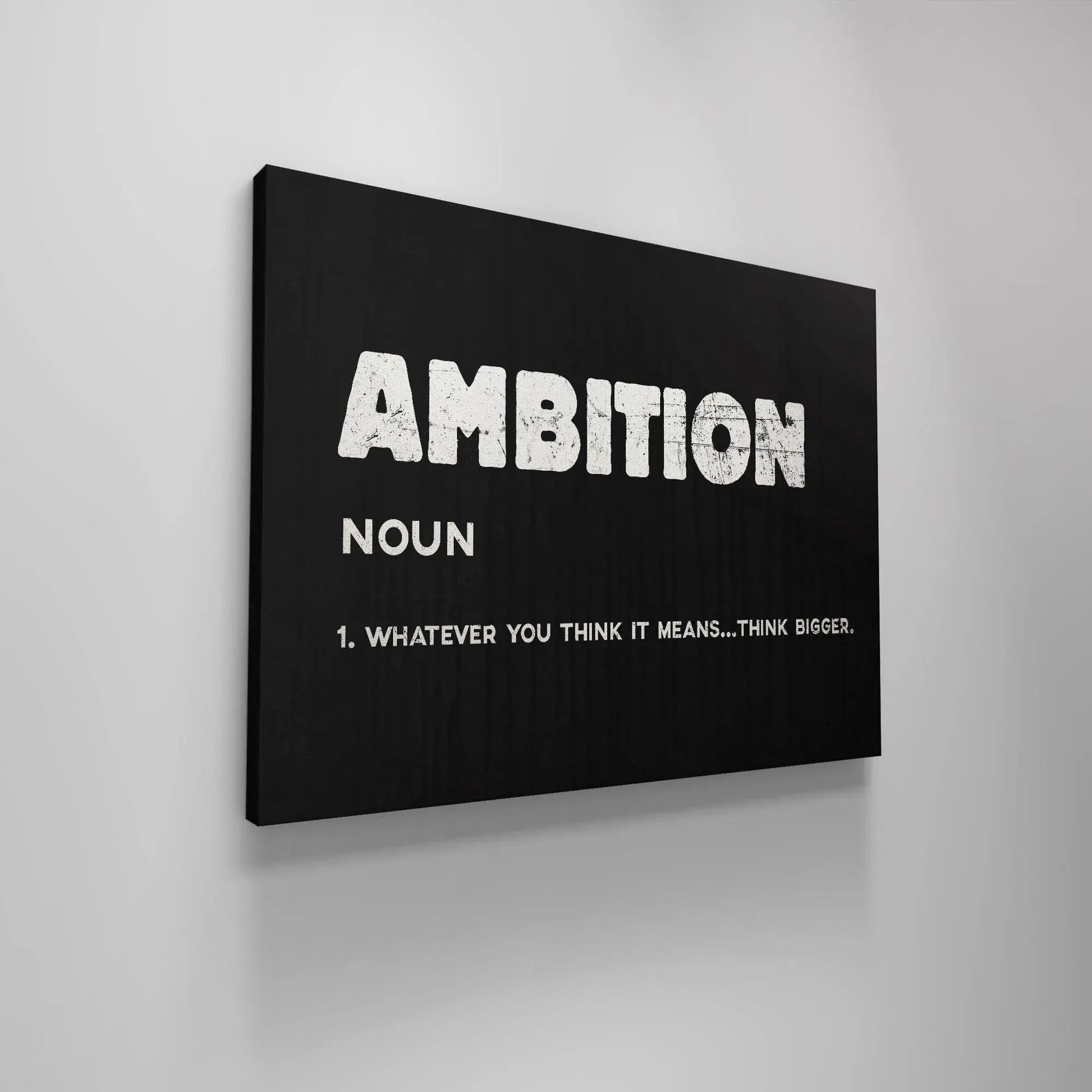 Lifestyle image showing the Ambition poster framed in black and leaning against a white brick wall.
