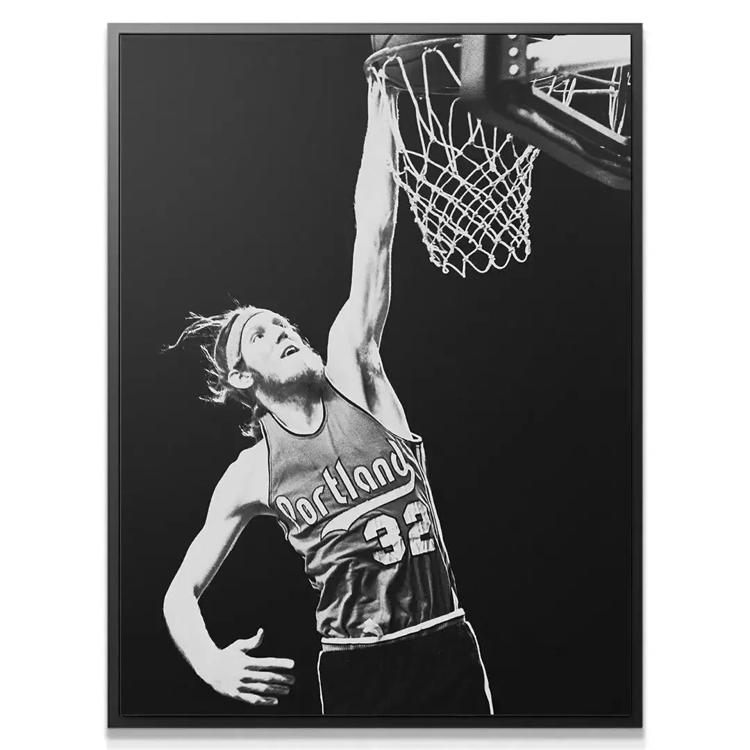 Action angle photo of Bill Walton - #2 stretching high above the rim, showcasing his impressive reach and determination.