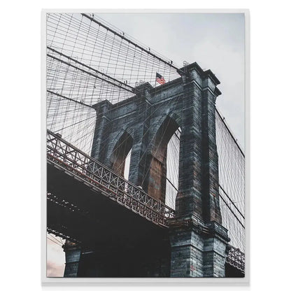 Dramatic black and white style photo of the suspension cables above the roadway of the Brooklyn Bridge.