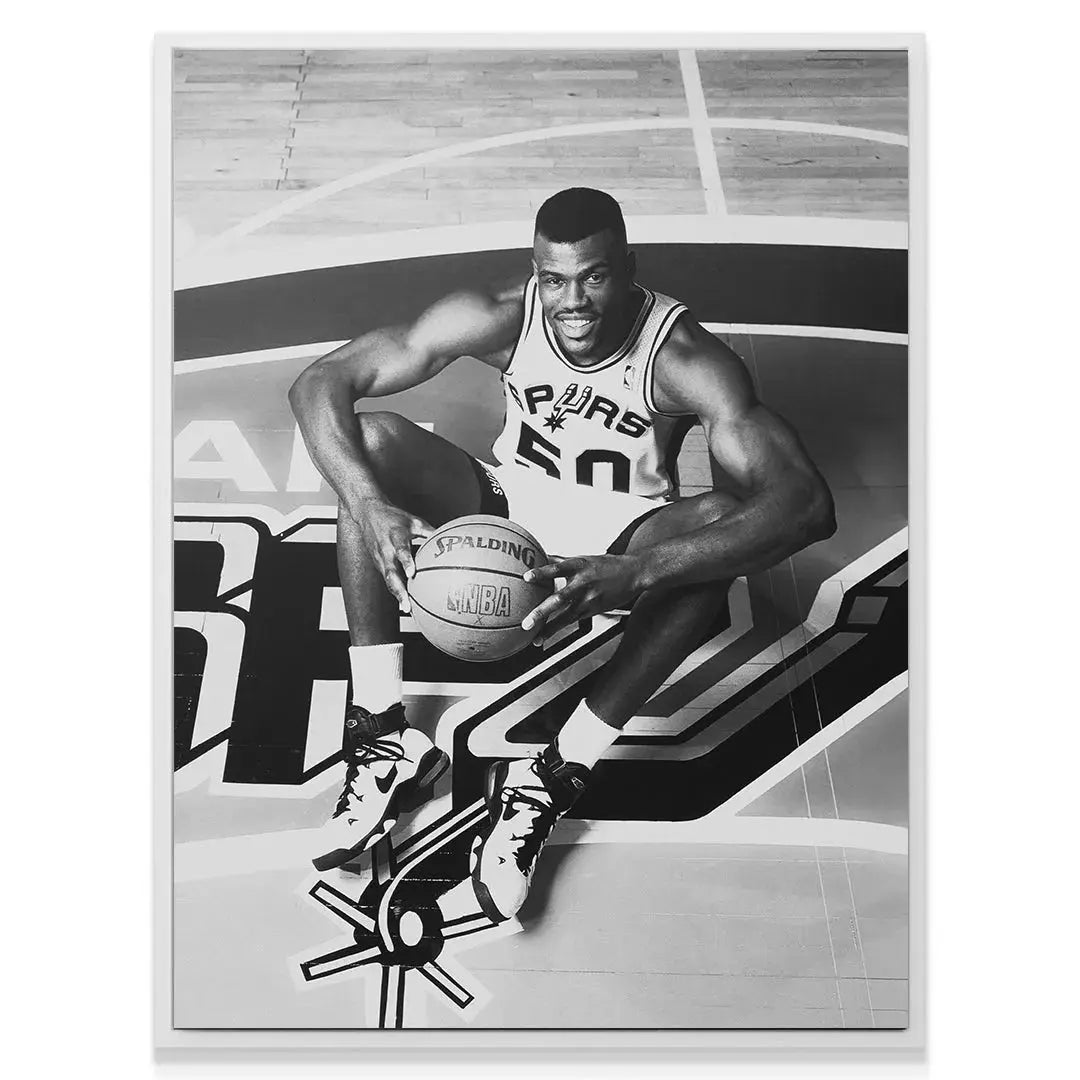 Full-body view of David Robinson - #1 showcasing his muscular physique and iconic Nike shoes on the painted court logo.