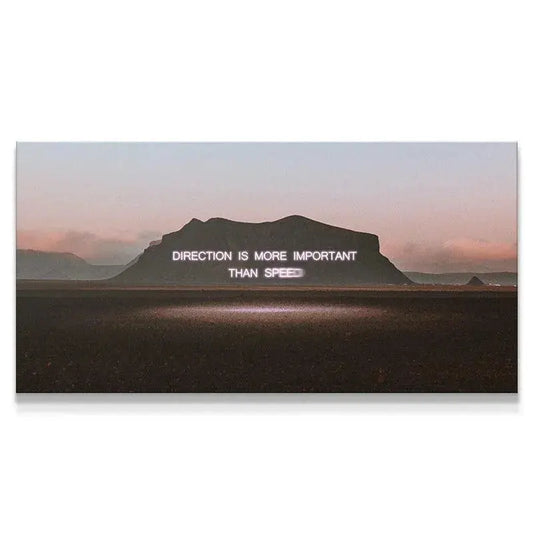 Wide landscape view of the 'Direction' quote glowing on the mountain silhouette at dusk.