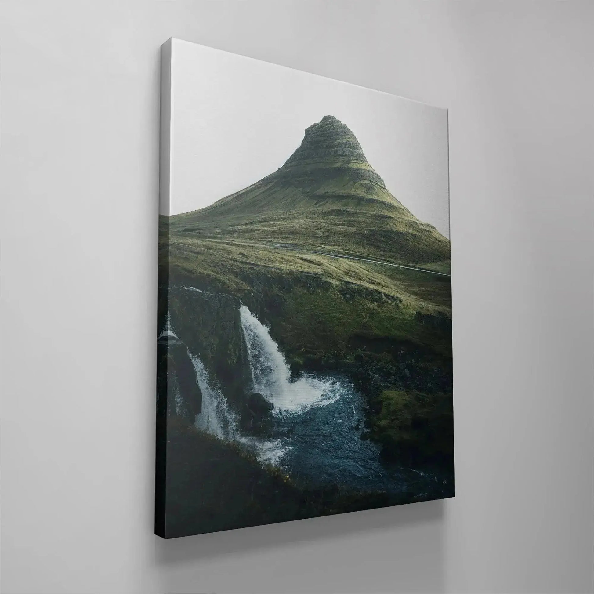The dark blue river meeting the black volcanic rock formations beneath the cascading falls in '(N)iceland'.