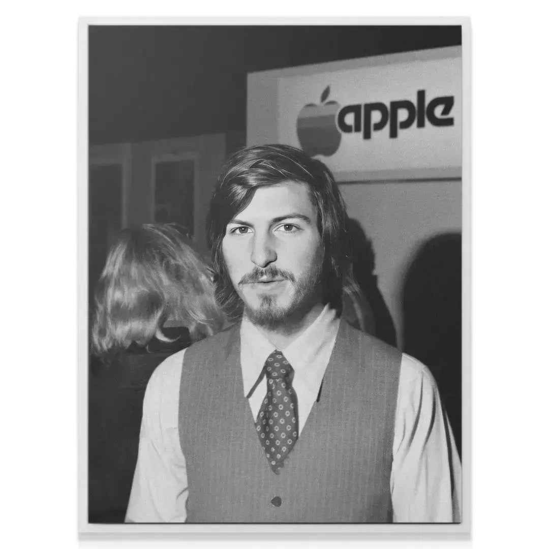 Angled shot showing Steve Jobs' profile and the original Apple typography backdrop.