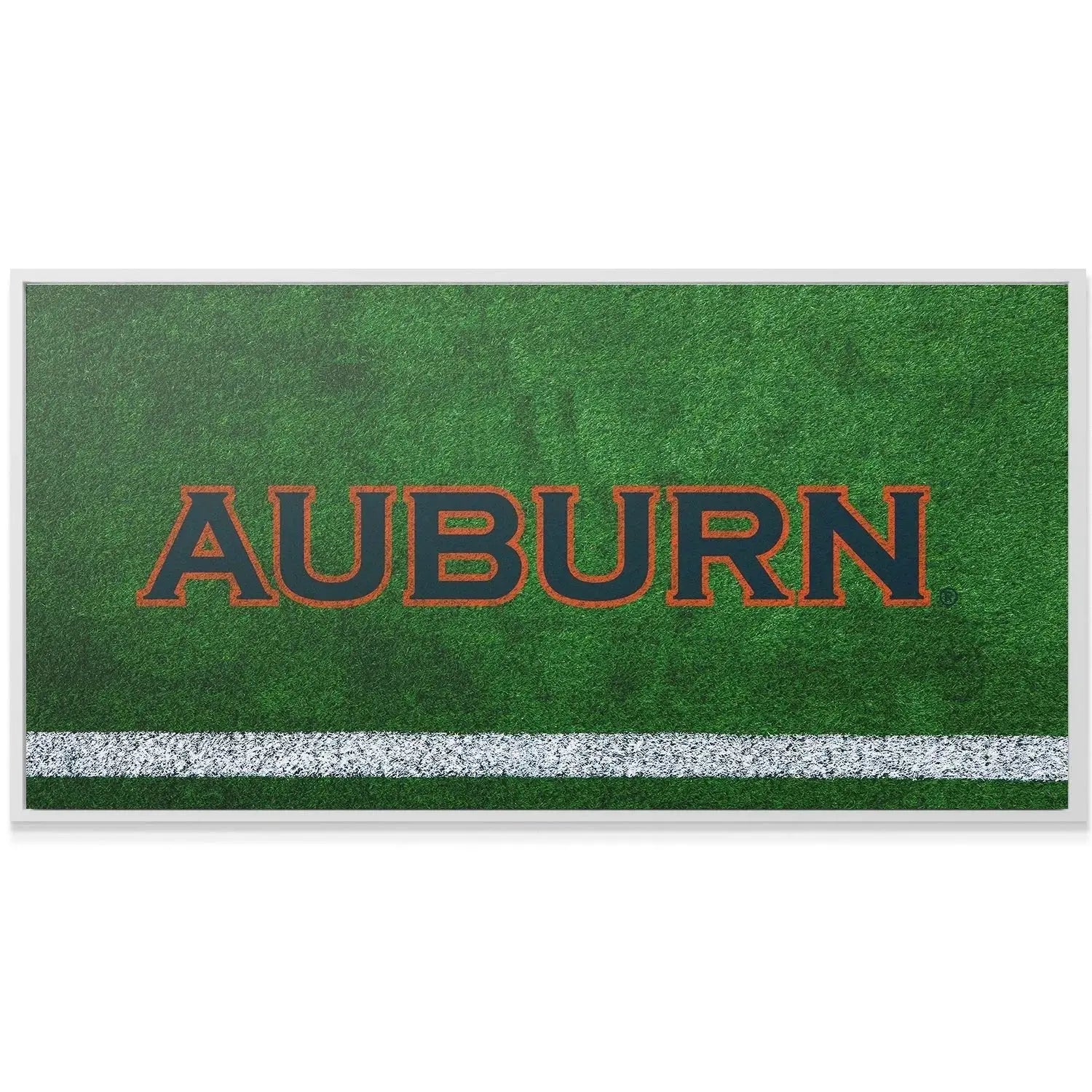 Macro shot emphasizing the deep green, textured grass fibers behind the Auburn - Field Logo.