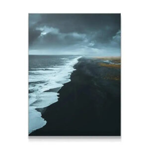 Aerial view of the Black Beach coastline receding into the dramatic mist and fog.
