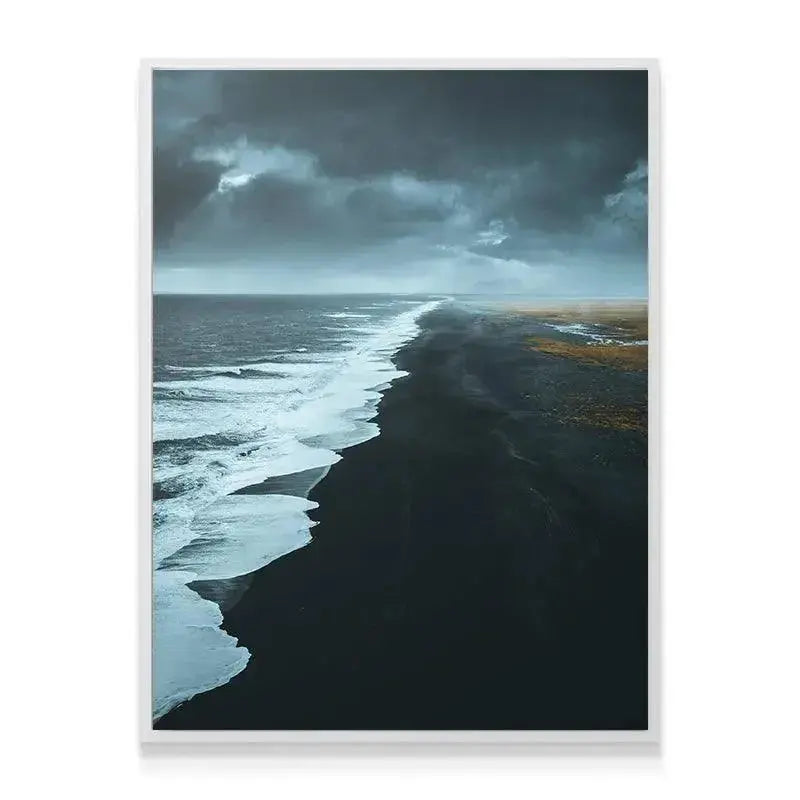 Wide landscape photograph showcasing the dark sand and heavy, stormy clouds above the Black Beach.