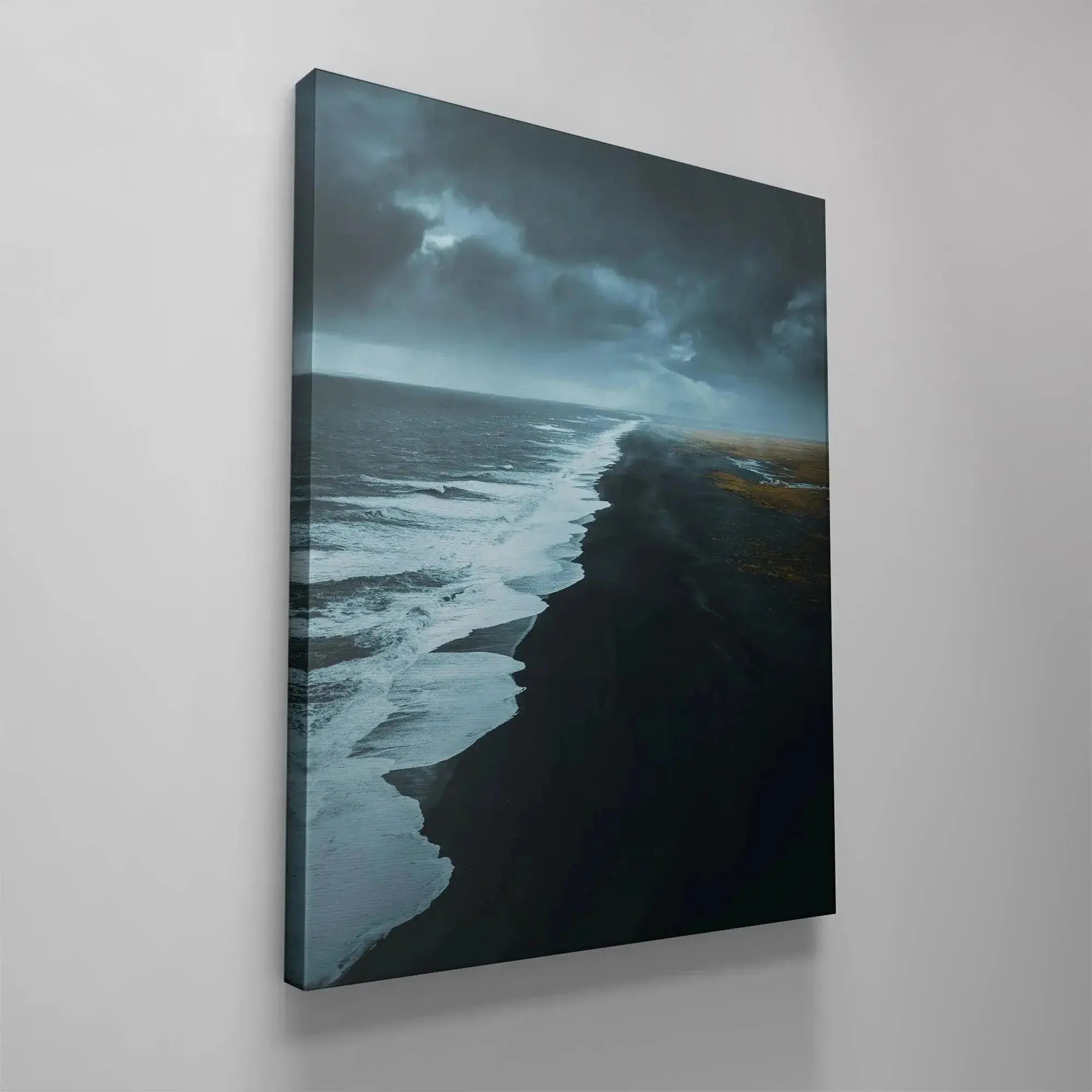 Lifestyle staging photo featuring the large canvas print of the desolate, powerful Black Beach in a modern living room.