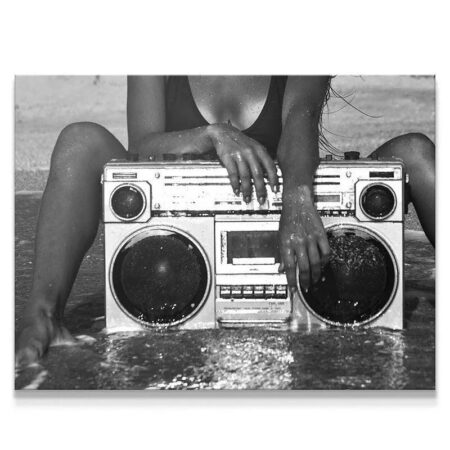 Full view of the woman sitting in water with the classic Brooklyn Boombox stereo.