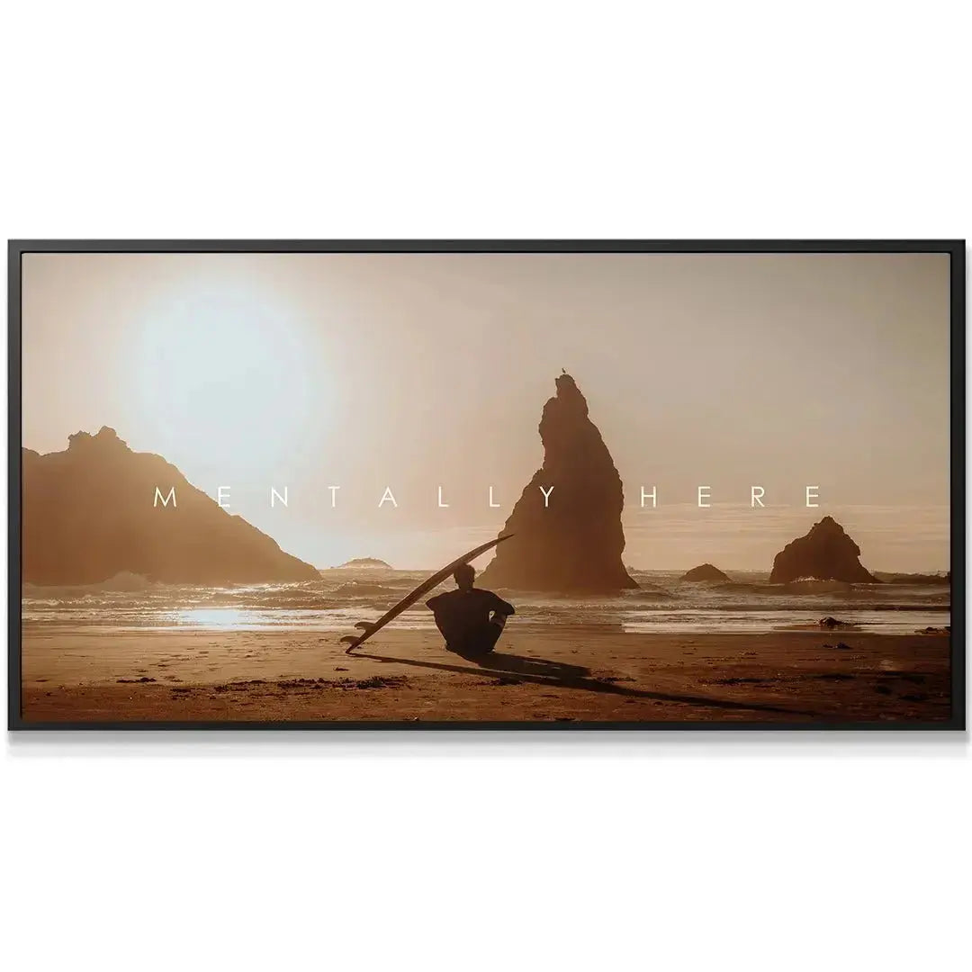 Close-up detail of the surfer sitting on the wet beach sand holding their board from 'Chris Henry - Mentally Here'.