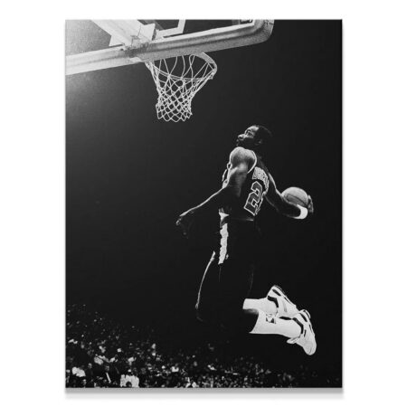 High-contrast black and white full-frame image of Clyde Drexler #4 completing a powerful dunk under intense spotlight.