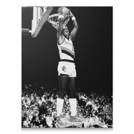 Full-length action shot of Clyde Drexler #5 completing a powerful slam dunk over a blurred crowd.