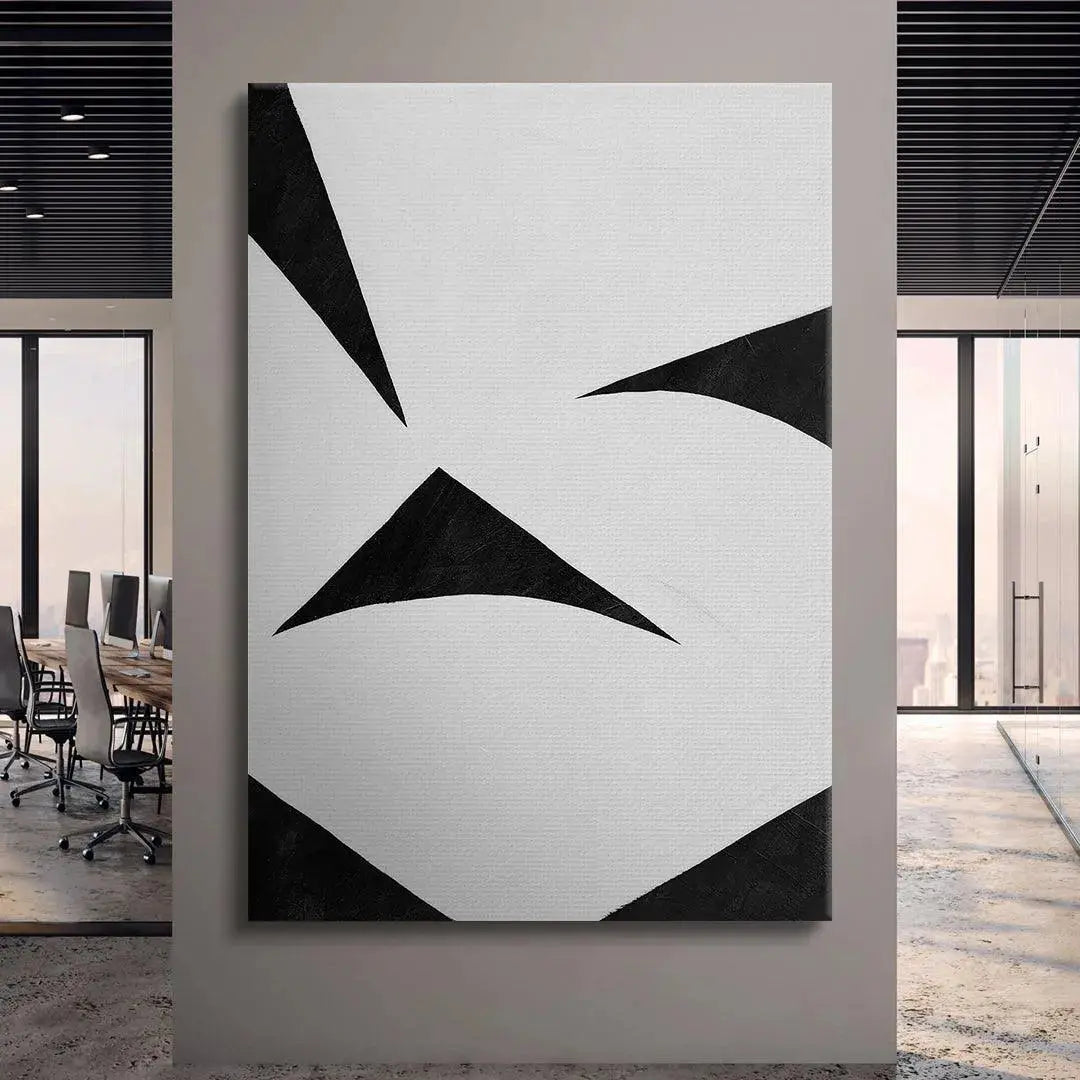 Lifestyle mock-up of Colliding Shapes Black N.6 hanging above a minimalist gray sofa in a contemporary loft setting.