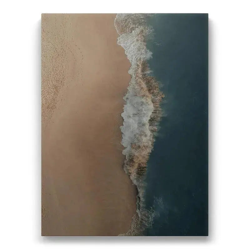 Aerial view of the exact point where wave foam meets golden sand, showcasing 'Crashed Symmetry'.