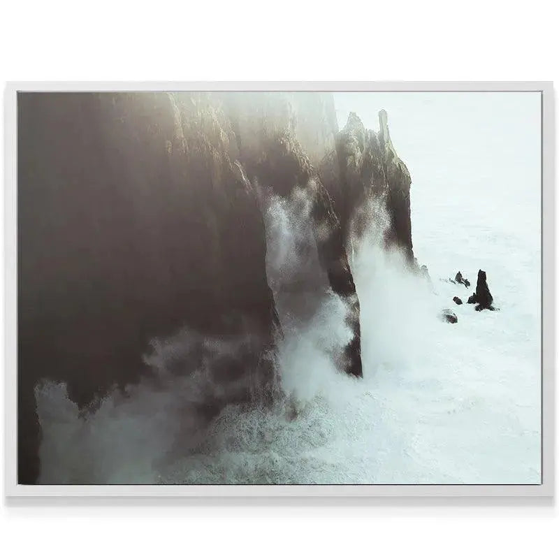 Wide view of the dramatic coastal seascape featuring powerful Crashing Waves and misty sunlight.