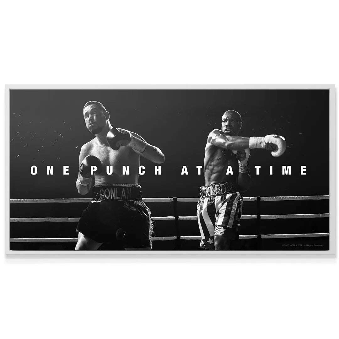 Horizontal view capturing the stark contrast and focus on the two boxers facing off in the ring: Creed - One Punch At A Time.