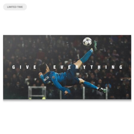 Wide shot of the inspirational 'Cristiano Ronaldo - Give Everything' poster showing the full bicycle kick motion against the stadium lights.