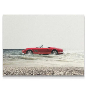 Red vintage convertible submerged in shallow sea water, embodying a carefree Day Off lifestyle.