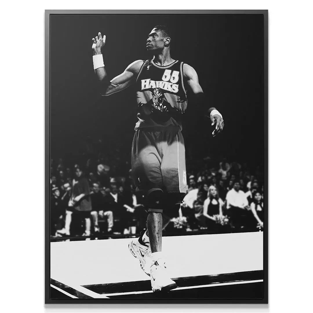 Close-up profile view of Dikembe Mutombo - #1, focusing on his concentrated expression and high raised hand.