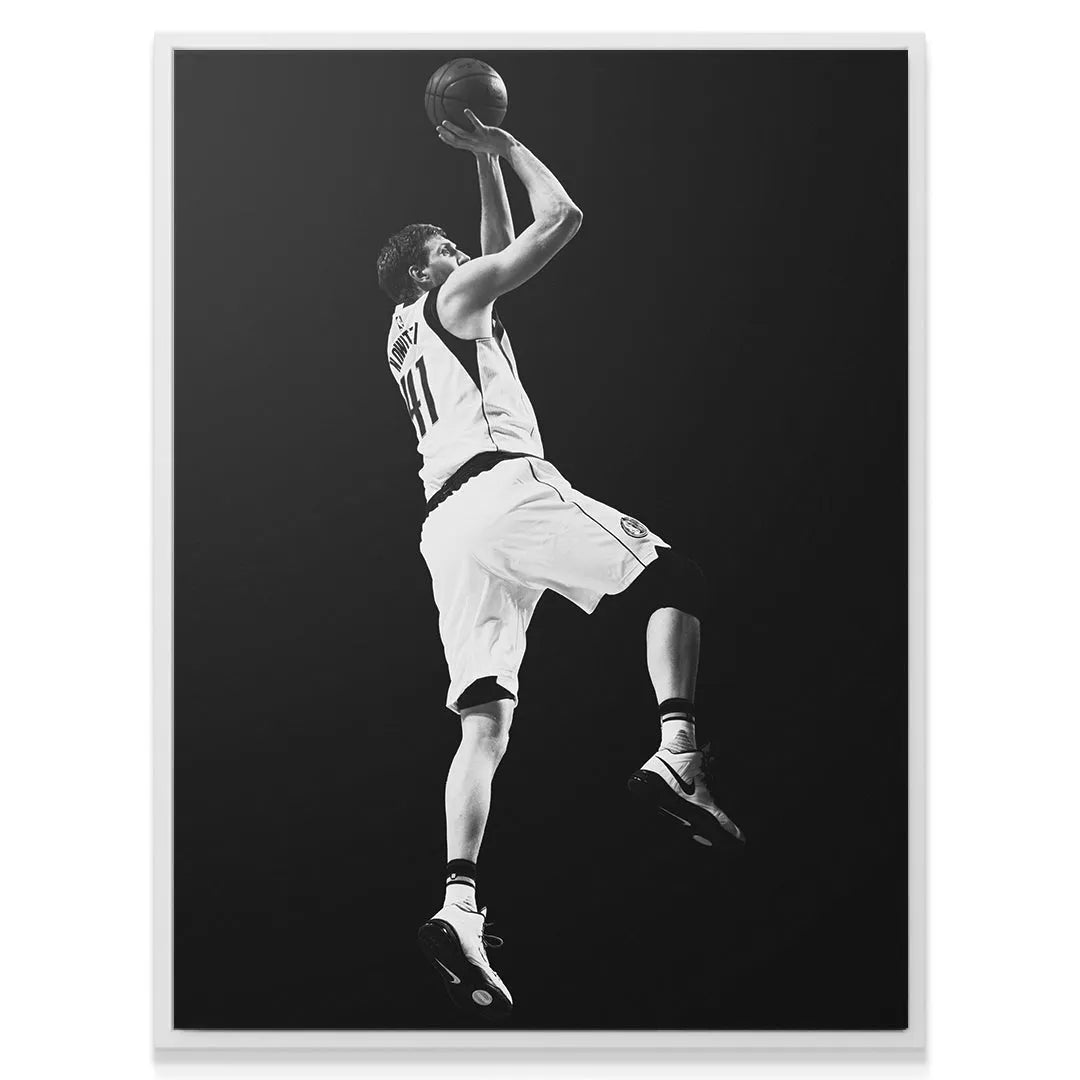 Full-length view of Dirk Nowitzki - #4 elevated against a pure black background, highlighting his perfect form.