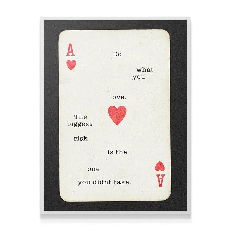 Lifestyle setting showing the framed "Do What You Love" print hanging above a minimalist office desk.