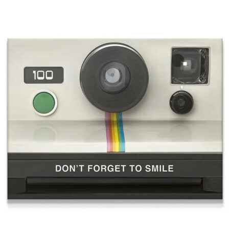 Close-up of the vintage instant camera lens with the rainbow stripe saying Don't Forget To Smile.