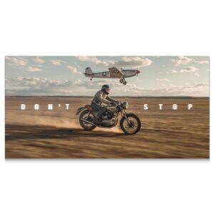 Wide shot of a motorcyclist and vintage airplane flying low over a dusty landscape, embodying 'Don't Stop Racing'.