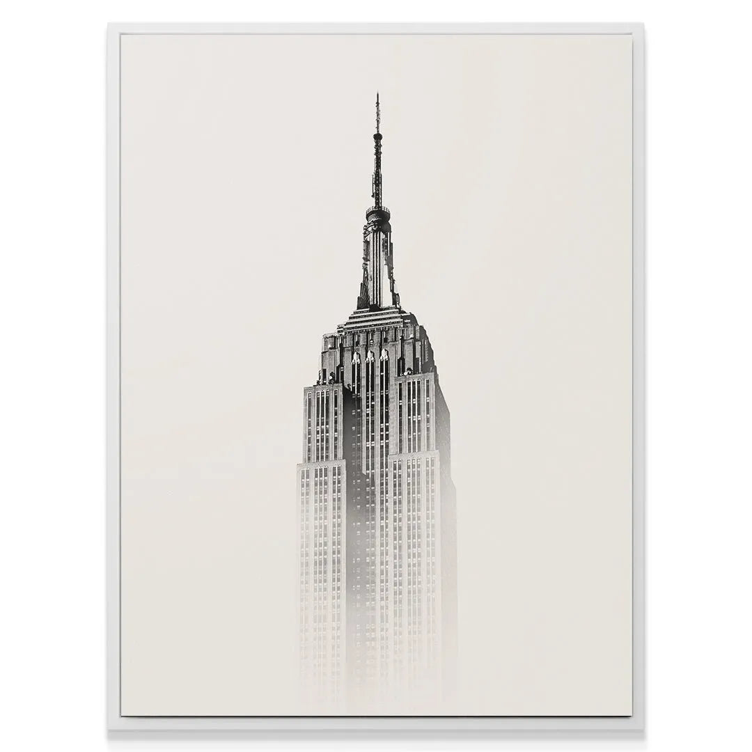 High-contrast photograph showing the antenna and structure of the Empire State fading into a light background.