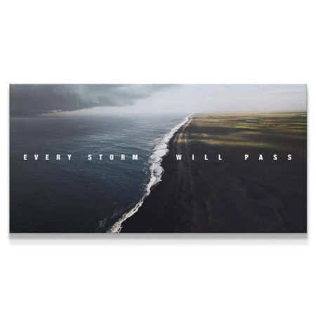 Aerial view of black sand beach with the motivating quote Every Storm Will Pass.