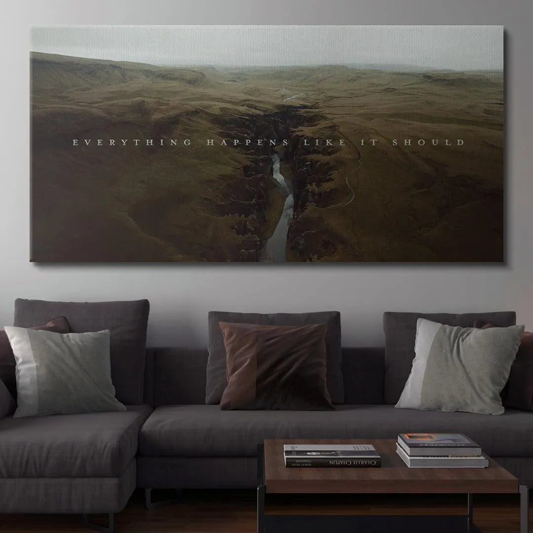 Moody, overcast landscape art showing a deep fissure riverbed, centered with "Everything Happens Like It Should."