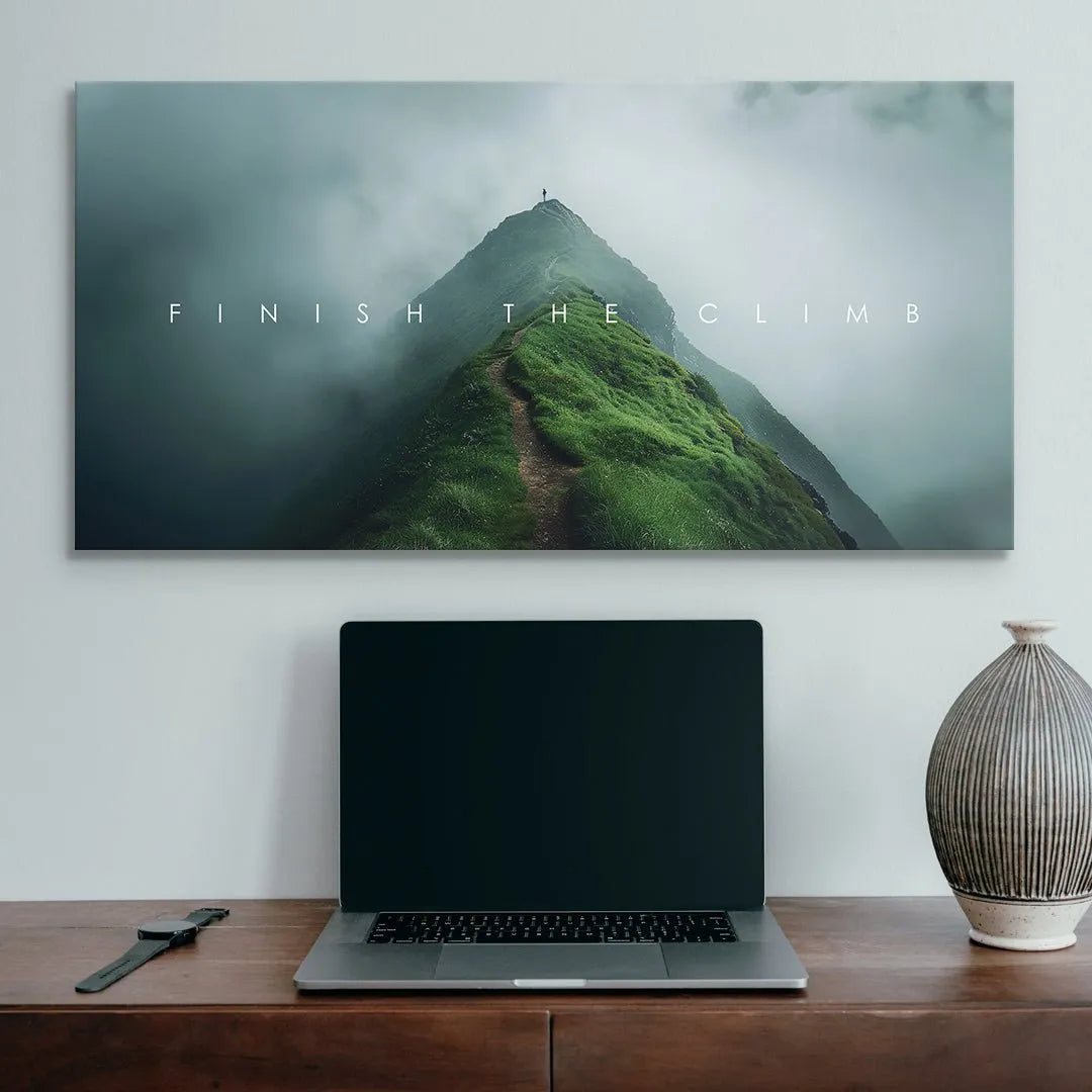 Panoramic landscape art depicting rugged terrain and the ultimate goal symbolized by Finish The Climb.