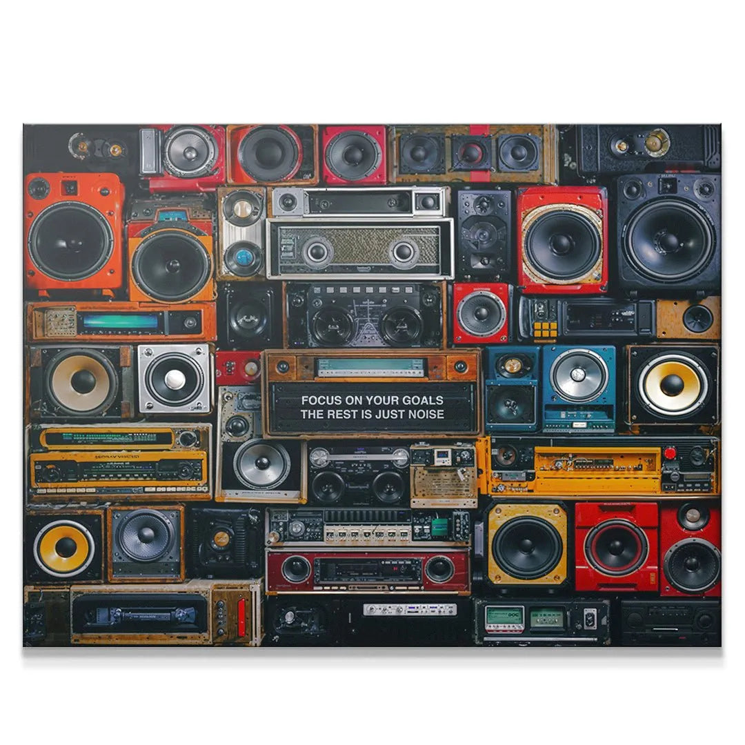 Vintage audio wall print reading 'Focus On Your Goals The Rest Is Just Noise' in an office setting.
