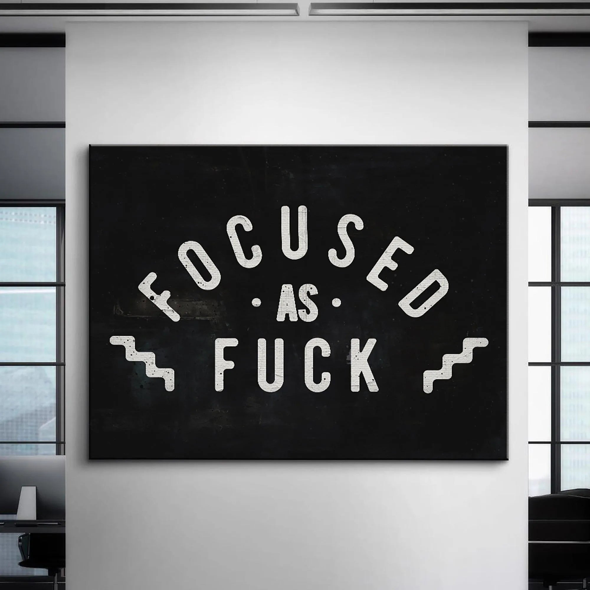 Lifestyle mock-up of the "Focused As Fuck" artwork hanging prominently in a minimalist home office setup.