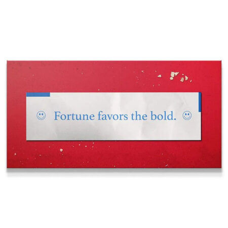 Extreme close-up of the blue text on the white slip reading "Fortune Favors The Bold" with small smiley face icons.