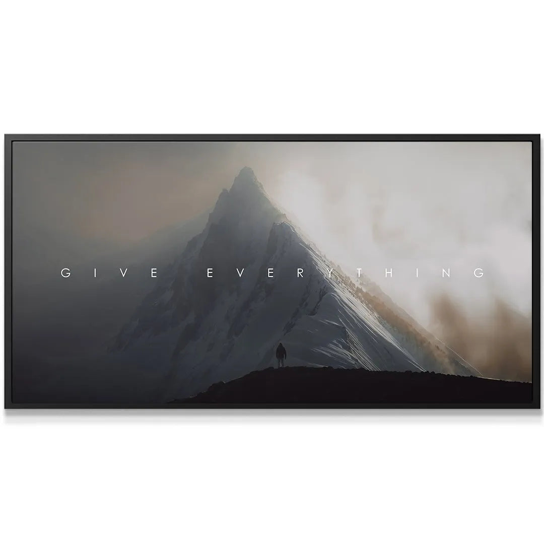 Close-up texture shot of the rugged, dark base where the climber stands, promoting the spirit to 'Give Everything'.