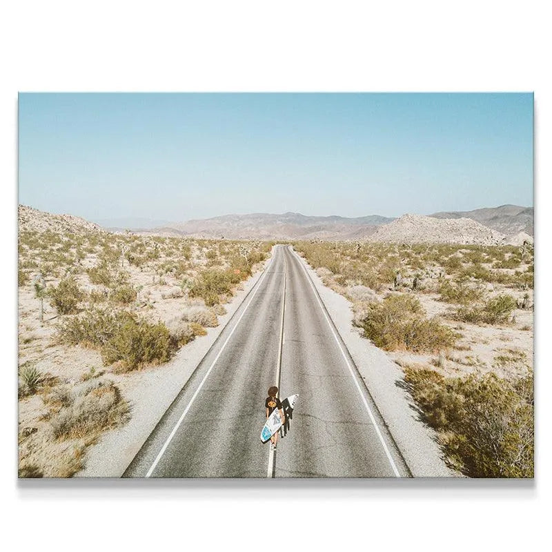 Overhead view of a person with a surfboard walking down a desert road, titled Going Places.