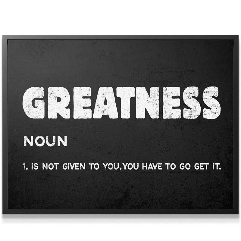 Motivational Greatness definition poster hanging in a modern home office setting.