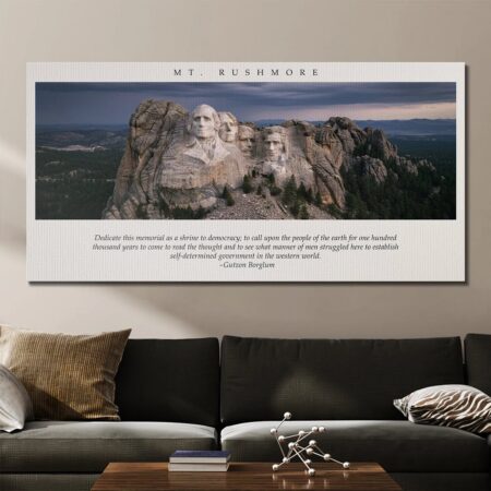 Wide view of the canvas art Gutzon Borglum - Mt. Rushmore displayed above a modern dark sofa.