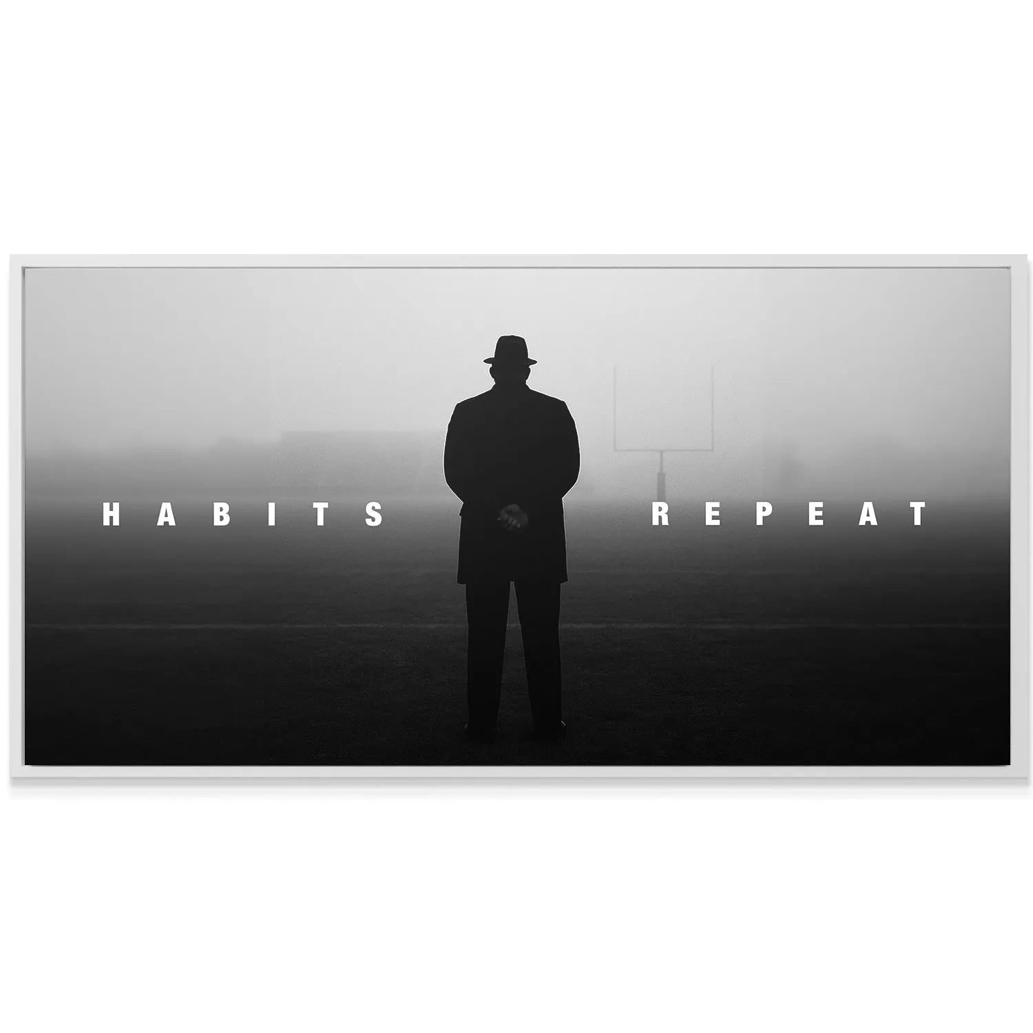 Monochromatic canvas art displaying the profound message 'Habits Repeat' hanging in a modern, minimalistic office setting.