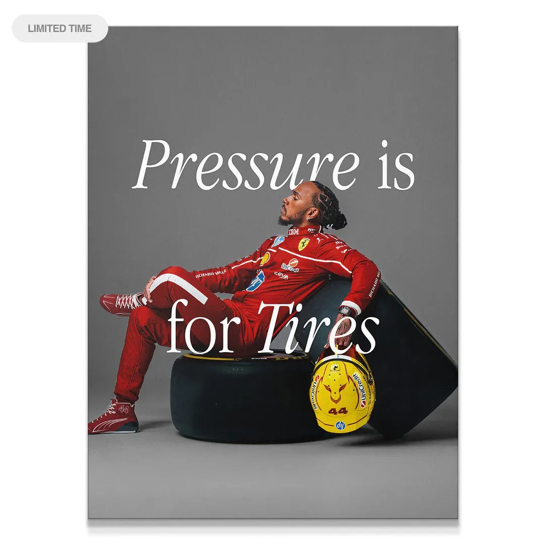 Full portrait of Lewis Hamilton relaxing on a tire, displaying the 'Hamilton - Pressure Is For Tires' quote clearly.