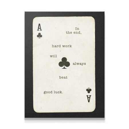 Close-up view of the central Ace of Clubs symbol on the print that reads 'Hard Work Beats Good Luck'.