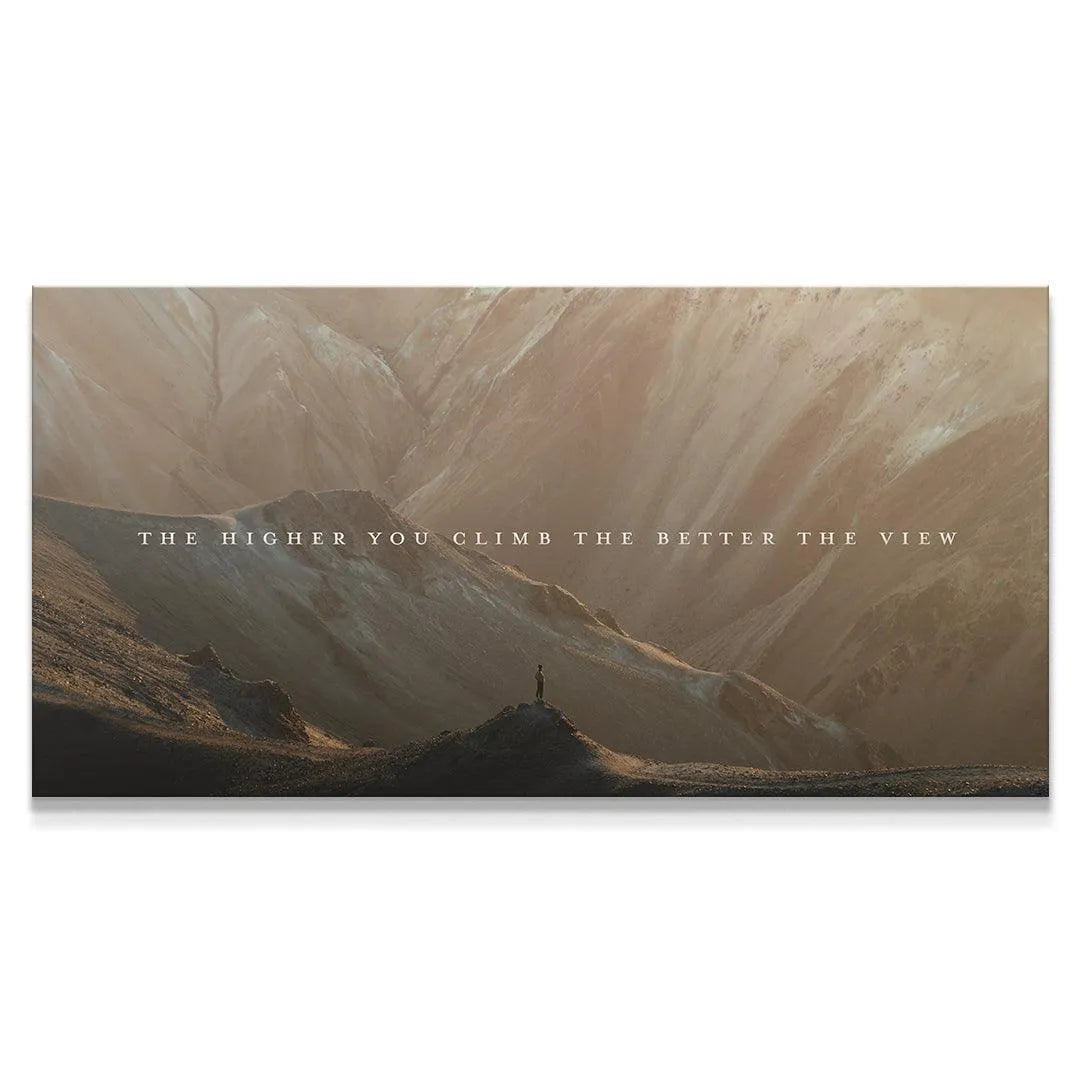 Detailed close-up of the figure standing on the peak in 'Higher You Climb' canvas art.