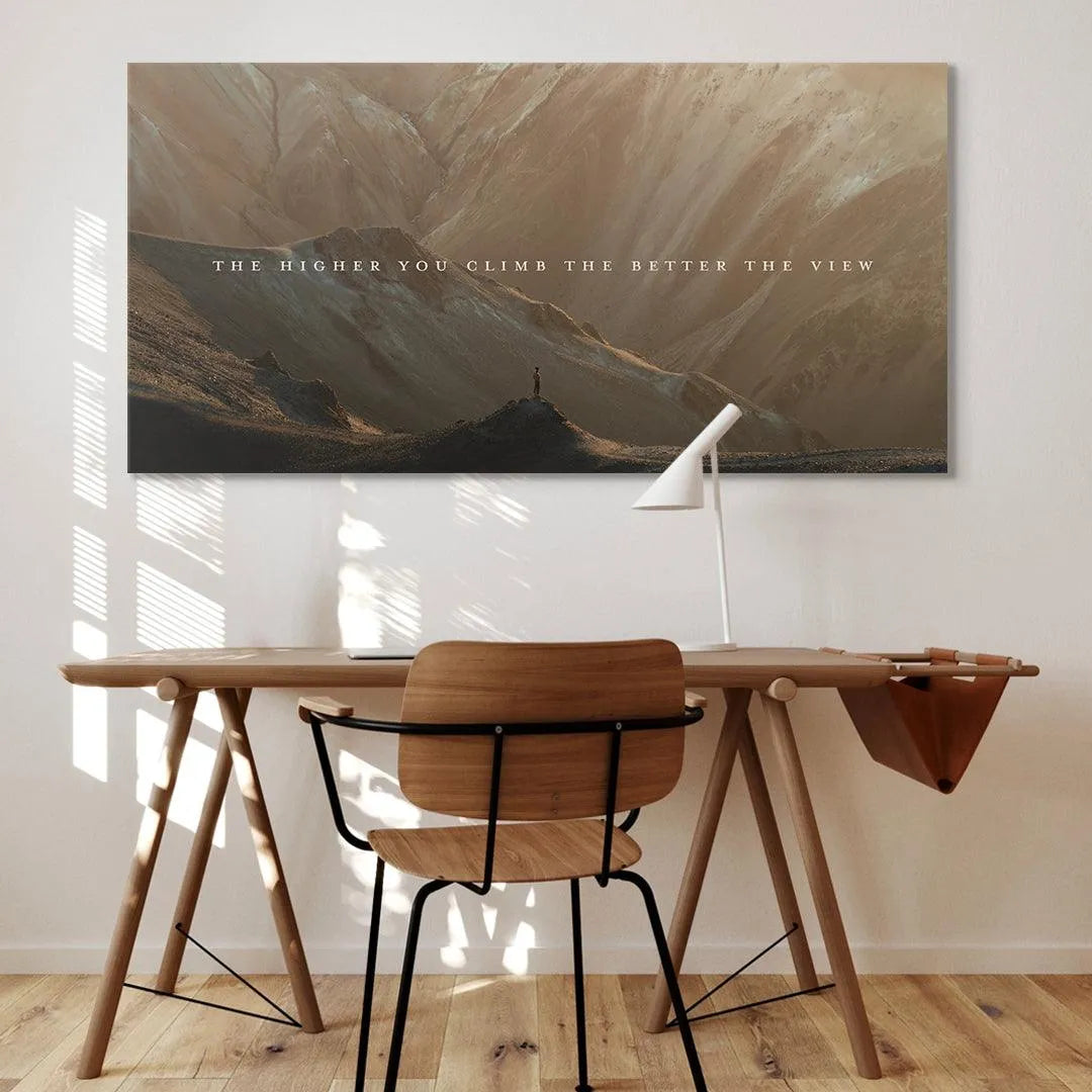 Lifestyle placement of the 'Higher You Climb' canvas hanging above a modern office desk.