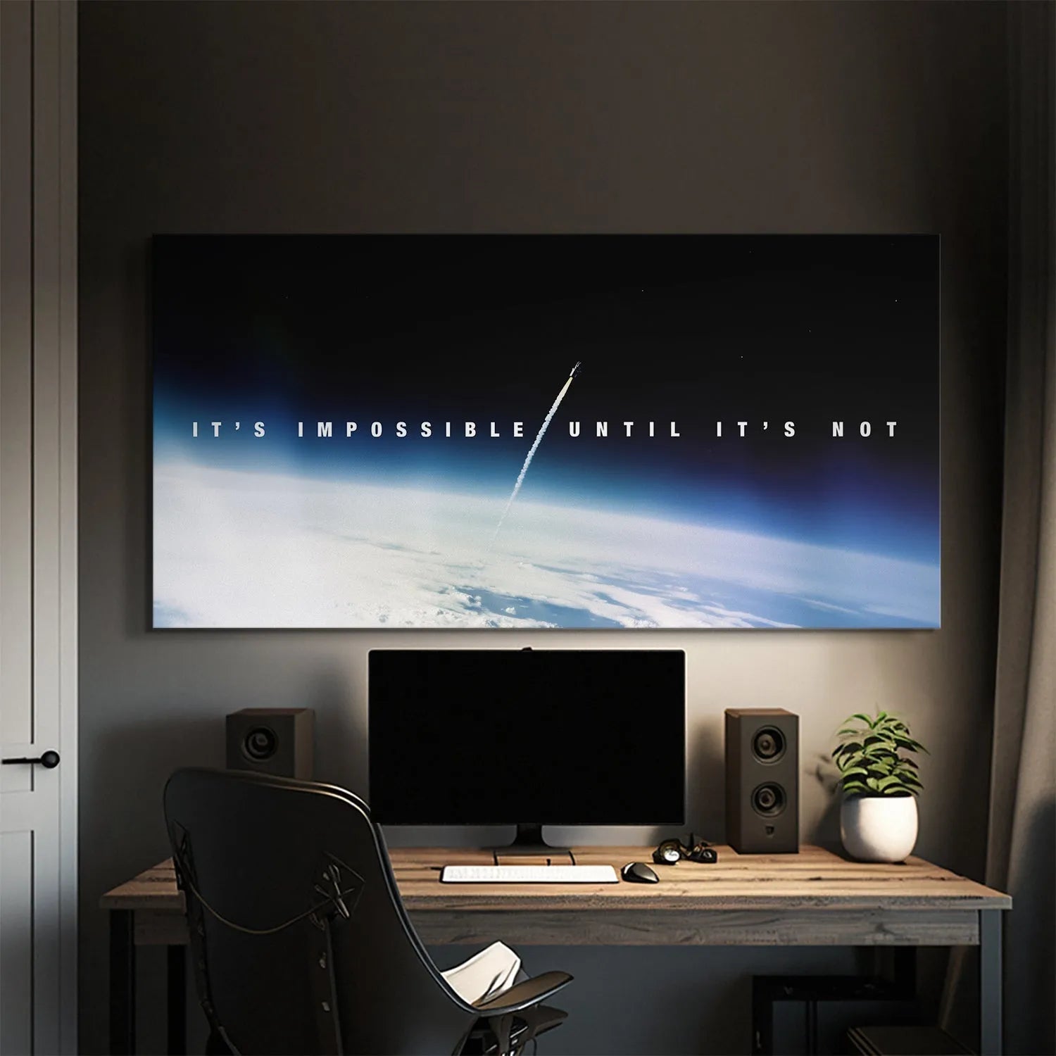 Lifestyle image of the canvas mounted above an office desk featuring "Impossible Until It's Not."